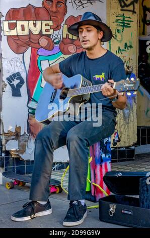 Un busker si esibisce su Dauphin Street circondato da graffiti Black Lives Matter, 31 ottobre 2020, a Mobile, Alabama. Foto Stock