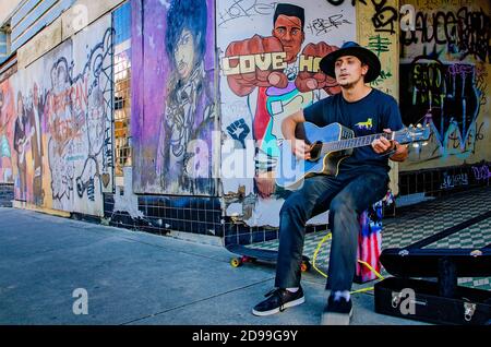 Un busker si esibisce su Dauphin Street circondato da graffiti Black Lives Matter, 31 ottobre 2020, a Mobile, Alabama. Foto Stock