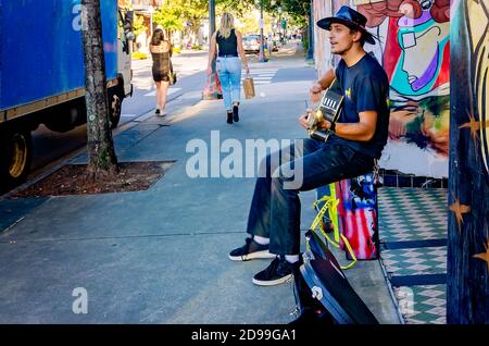 Un busker si esibisce su Dauphin Street circondato da graffiti Black Lives Matter, 31 ottobre 2020, a Mobile, Alabama. Foto Stock