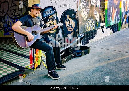 Un busker si esibisce su Dauphin Street circondato da graffiti Black Lives Matter, 31 ottobre 2020, a Mobile, Alabama. Foto Stock