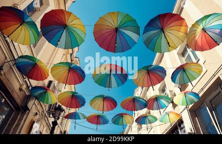 Colorati ombrelli decorativi appesi in città fuoco selettivo Foto Stock