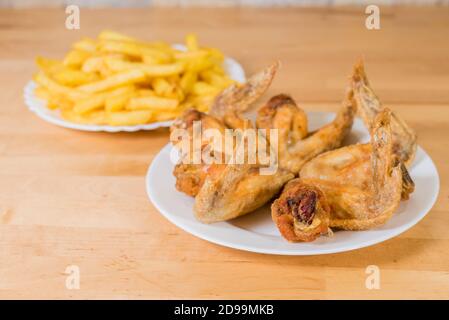 ali di pollo fritte con patatine fritte Foto Stock