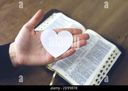 Passa la preghiera femminile per caricare con cuore rotto nelle mani sulla bibbia, il concetto prega per la liberazione, il peccato, nessuna libertà. Foto Stock