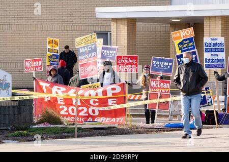 Manchester, New Hampshire, Stati Uniti. 3 Nov 2020. I sostenitori di Trump hanno dei segnali fuori da un luogo di voto mentre un elettore esce al giorno delle elezioni della Memorial High School. Credit: Keiko Hiromi/AFLO/Alamy Live News Foto Stock