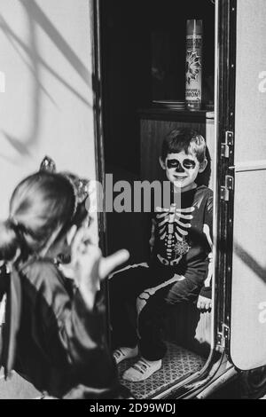 Immagine in scala di grigi di bella sorella e fratello che indossa costumi di Halloween Foto Stock