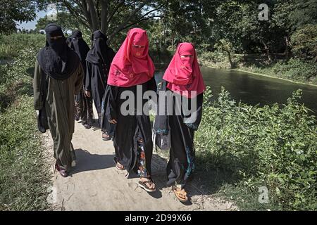 Dhaka, Bangladesh, luglio 2009 - UN gruppo di donne vestite a Burka cammina lungo la riva di un canale. Foto Stock