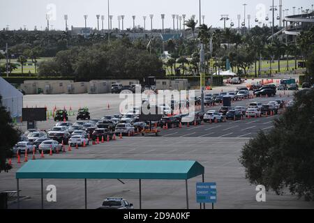 Miami Gardens, Florida, Stati Uniti. 03 Nov 2020. Le automobili aspettano in fila al Coronavirus (COVID-19) guida nel sito di test, il giorno delle elezioni presidenziali del 2020, istituito nel parcheggio dell'Hard Rock Stadium come la Florida ha riferito un aumento di casi COVID-19 il 3 novembre 2020 a Miami Gardens, Florida. Credit: Mpi04/Media Punch/Alamy Live News Foto Stock