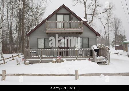Case innevate a Prudenville vicino al bellissimo lago Michigan in inverno Foto Stock