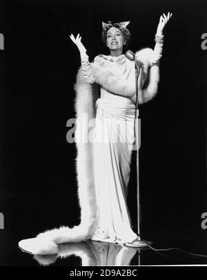1951 : l'attrice del film GLORIA SWANSON ( Chicago 1898 - New York 1983 ) come norma Desmond in SUNSET BOULEVARD ( Viale del Tramonto ) di Billy Wilder, costume di Edith HEAD , Paramount publicity Still - FILM - CINEMA - attrice cinematografia - VAMP - DIVA - DIVINA - DIVINE - Hollywood su Hollywood - pelliccia - parruca - ali - ali - guanti lunghi - guanti lunghi - microfono - microfono - sorriso - neo --- Archivio GBB Foto Stock