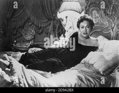 1951 : l'attrice del film GLORIA SWANSON ( Chicago 1898 - New York 1983 ) come norma Desmond in SUNSET BOULEVARD ( Viale del Tramonto ) di Billy Wilder, costume di Edith HEAD , Paramount publicity Still - FILM - CINEMA - attrice cinematografia - VAMP - DIVA - DIVINA - DIVINE - Hollywood su Hollywood - mole - neo - letto - letto - letto - lettone - guanciale - cuscino © Archivio GBB / Foto Stock