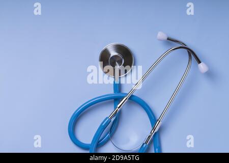 Primo piano dello stetoscopio Blu del medico per il controllo su sfondo blu. Vista dall'alto . Spazio di copia Foto Stock