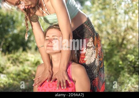 Massaggiatrice esperta applica le sue abilità di massaggio sul suo cliente alla luce del giorno. Foto Stock