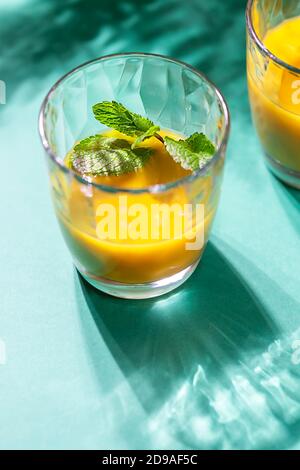 Mango Lassi, Lassie curcuma. Frullato con curcuma con foglie di menta . Sana bevanda fredda estiva probiotica indiana. Foto Stock
