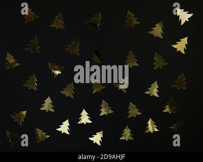 Confetti sull'albero di Natale su sfondo nero. Festivo piatto posato. Foto Stock