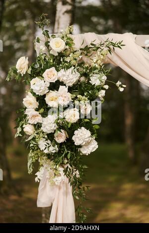 Decorazioni per matrimoni. Fiori sull'arco di nozze. Decorazione di una celebrazione di nozze. Foto Stock