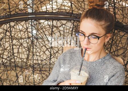 Cocktail di bevande per donna hipster giovane milleniale in un caffè all'aperto Foto Stock