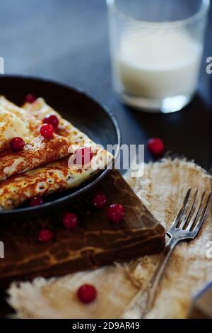 Cibo nazionale russo. Pancake in una padella con latte. Stile rustico Foto Stock