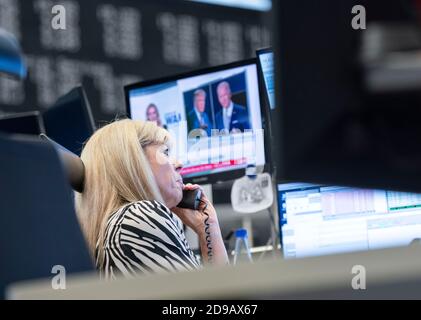 04 novembre 2020, Hessen, Francoforte sul meno: Un commerciante si trova nella sala di negoziazione della Borsa di Francoforte di fronte ai suoi monitor, che mostrano anche relazioni sulle elezioni presidenziali americane. Foto: Frank Rumpenhorst/dpa Foto Stock