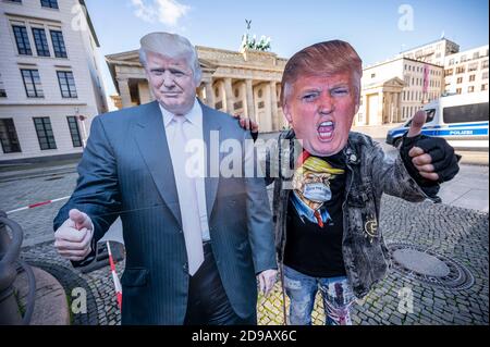 Berlino, Germania. 04Nov 2020. Un sostenitore del presidente americano Trump si presenta di fronte alla porta di Brandeburgo con un cartoncino e una maschera di Trump. Più di 200 milioni di americani sono stati chiamati ad eleggere un nuovo presidente e i membri della Camera dei rappresentanti. Credit: Fabian Sommer/dpa/Alamy Live News Foto Stock