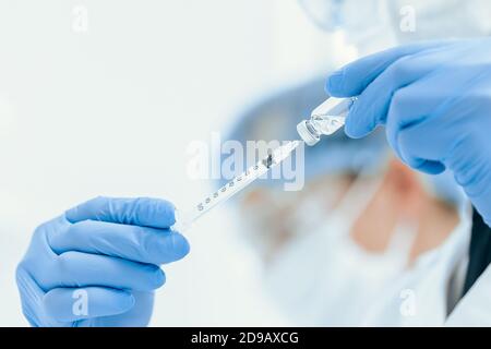 primo piano siringa con un nuovo vaccino nelle mani di un medico. Foto Stock