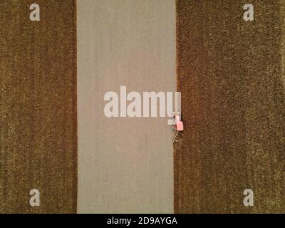 Vista aerea dell'agricoltore nel trattore preparazione di terreni con coltivatore a letto di semina come parte di lavori agricoli in campi Foto Stock