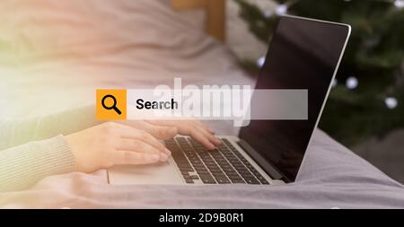 Donna irriconoscibile che naviga in Internet usando il laptop che lavora a casa Foto Stock