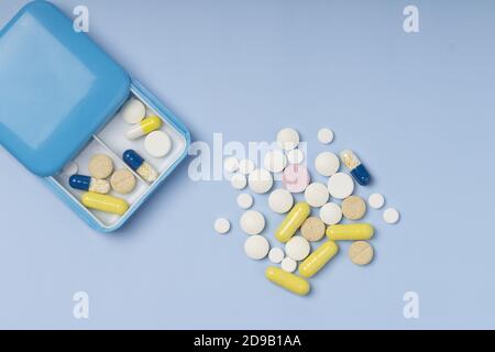 scatola di pillole con pillole su sfondo blu. scatola di compresse, vitamine per il trattamento di routine. Vista dall'alto Foto Stock