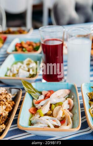 Pesce alla griglia, insalate e verdure. Frutti di mare, carne alla griglia, meze, raki, ouzo, Antipasti e insalate al tavolo nel ristorante di pesce greco o turco Foto Stock