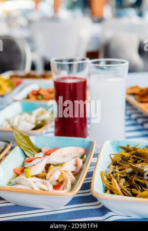 Pesce alla griglia, insalate e verdure. Frutti di mare, carne alla griglia, meze, raki, ouzo, Antipasti e insalate al tavolo nel ristorante di pesce greco o turco Foto Stock