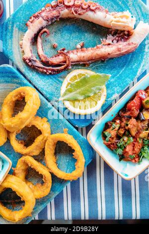 Frutti di mare, carne alla griglia, meze, erbe, pesce, Raki, ouzo, antipasti e insalate in greco o turco ristorante di pesce sul tavolo per cena o pranzo Foto Stock