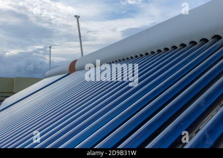 pannelli solari e tubi installati sui tetti della casa e. costruzione di piani per risparmiare energia per il riscaldamento dell'acqua Foto Stock