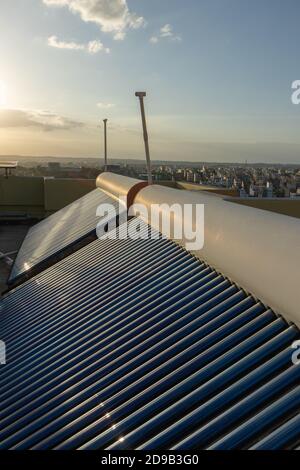 pannelli solari e tubi installati sul tetto delle case ed edifici per conservare energia Foto Stock