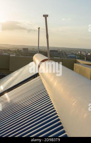 pannelli solari e tubi installati sui tetti della casa e. costruzione di piani per risparmiare energia per il riscaldamento dell'acqua Foto Stock