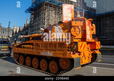 Westminster, Londra, Regno Unito. 4 Nov 2020. Un ex British Army Abbott Tank (più correttamente una pistola semovente) ha guidato intorno a Westminster e al Parlamento per protestare contro la chiusura delle palestre durante il blocco di Coronavirus COVID-19. L'arancio de-mobbed Vickers Abbot FV433 veicolo blindato sta facendo pubblicità a Grenade, una barra di nutrizione. Al di fuori del Parlamento Foto Stock