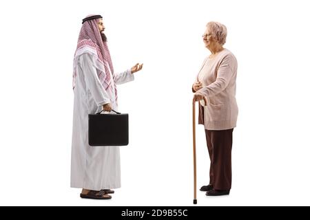 Foto di profilo a lunghezza intera di un uomo d'affari arabo in un thobe che parla con una signora anziana isolata su sfondo bianco Foto Stock
