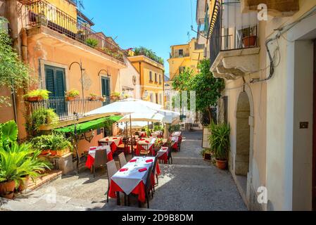 Vista della colorata e stretta strada pedonale con caffè nel centro storico di Taormina. Sicilia, Italia Foto Stock