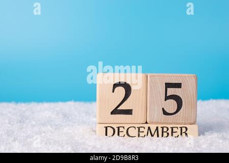 Primo piano foto del calendario dei cubetti di legno che mostra il 25° di dicembre in piedi nella neve con spazio per il testo vuoto luogo vuoto Foto Stock