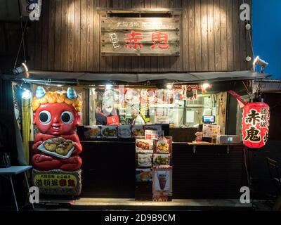 Osaka, Kansai, Japan - piccolo ristorante di Dotonbori che vende takoyaki, uno spuntino giapponese riempito di polpo e cucinato in una speciale padella modellata. Foto Stock