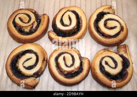 Un primo piano di dolci alla cannella appena sfornati pronti per glassa Foto Stock