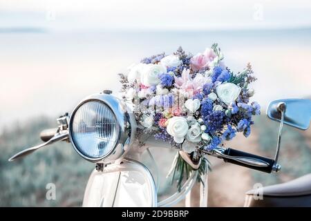 Effetto di sfocatura. Un grande bel bouquet nuziale di rose bianche e peonie. Il bouquet di nozze è sdraiato su una bici retrò. Foto Stock