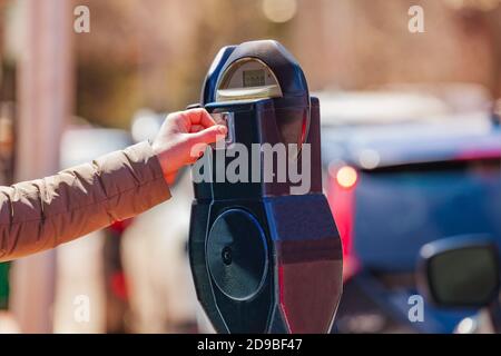 Donna paga sul palo del parchimetro di strada negli Stati Uniti città Foto Stock