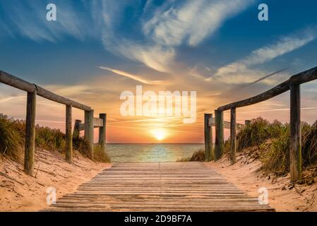 Percorso sulla spiaggia che conduce all'oceano con spettacolare alba Foto Stock