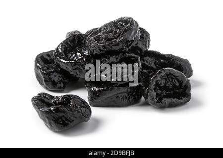 Le prugne secche si avvicinano su sfondo bianco Foto Stock