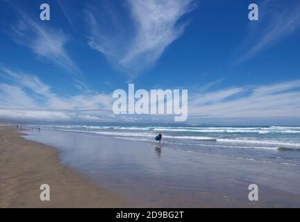 Quattro persone, camminando lungo Ninety Mile Beach, North Island, Nuova Zelanda Foto Stock