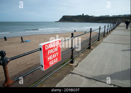 Cartello 'Danger from Heavy Seas' a Scarborough North Bay, Yorkshire, Inghilterra Foto Stock