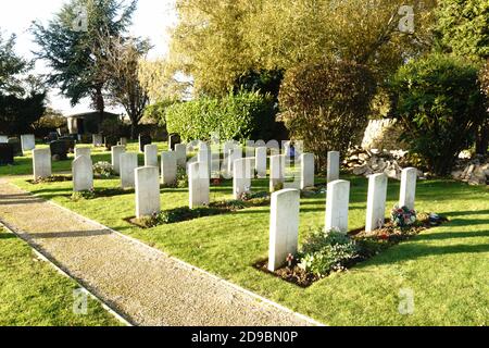 Kidlington, Oxfordshire, Regno Unito 4 novembre 2020. Il sole tramonta su tombe decorate con papaveri rossi e croci fatte da parrocchiani, e in mostra presso il sito delle tombe di guerra del Commonwealth, situato dietro la chiesa di Santa Maria, Kidlington. Ci sono 25 tombe nel cimitero di Kidlington, e 3 tombe nel cimitero. I servizi del giorno della memoria sono stati frenati quest'anno a causa della pandemia del coronavirus. Bridget Catterall/Alamy Live News. Foto Stock