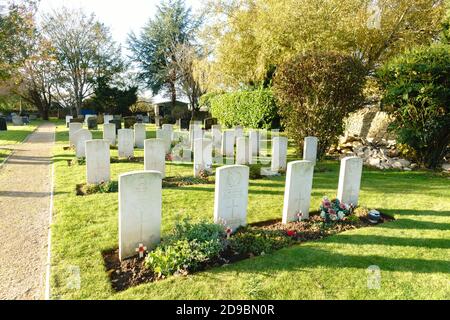 Kidlington, Oxfordshire, Regno Unito 4 novembre 2020. Il sole tramonta su tombe decorate con papaveri rossi e croci fatte da parrocchiani, e in mostra presso il sito delle tombe di guerra del Commonwealth, situato dietro la chiesa di Santa Maria, Kidlington. Ci sono 25 tombe nel cimitero di Kidlington, e 3 tombe nel cimitero. I servizi del giorno della memoria sono stati frenati quest'anno a causa della pandemia del coronavirus. Bridget Catterall/Alamy Live News. Foto Stock