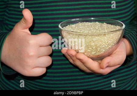 Il bambino tiene una lastra di vetro con la sua mano sinistra, e mostra come con la sua mano destra. Primo piano. Dettagli. Foto Stock