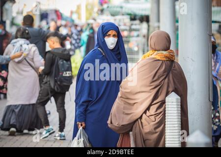 Londra, Regno Unito - 3 novembre 2020 - una donna musulmana che indossa un chador e una maschera mentre si acquista al mercato di Walthamstow Foto Stock