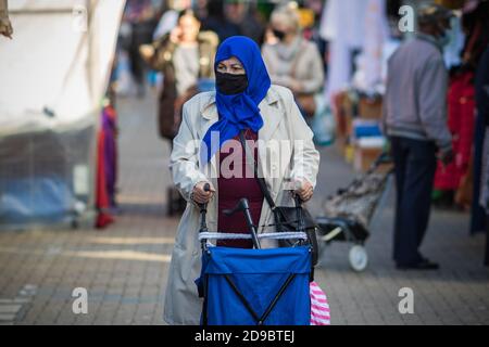 Londra, Regno Unito - 3 novembre 2020 - una donna musulmana asiatica che indossa una maschera facciale e un hijab mentre si acquista al mercato di Walthamstow Foto Stock